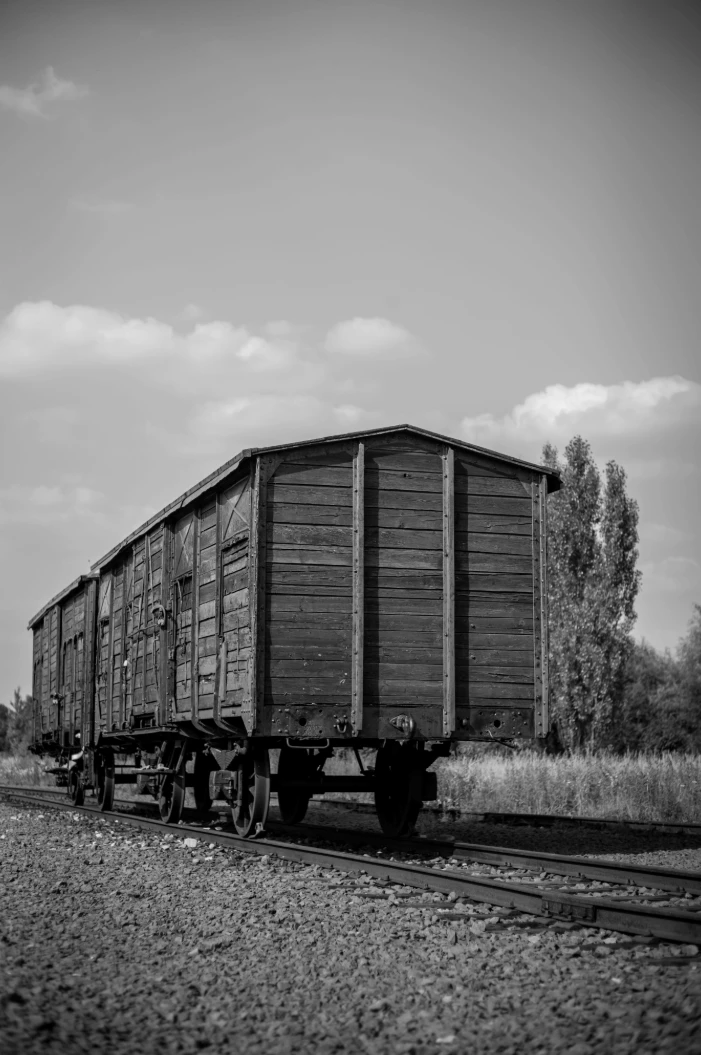 A black and white photograph of an old wooden container on a railway.