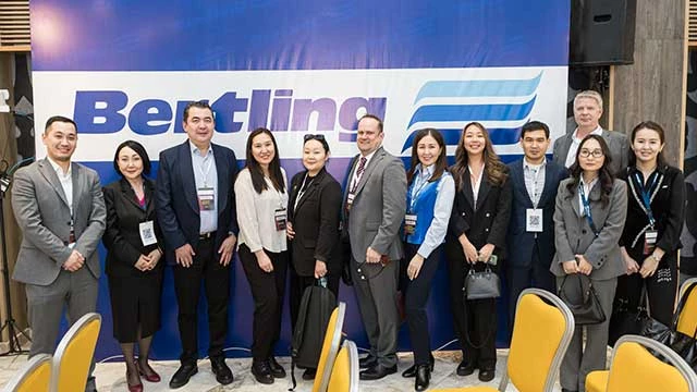 Twelve people both men and woman standing in front of Bertling logo