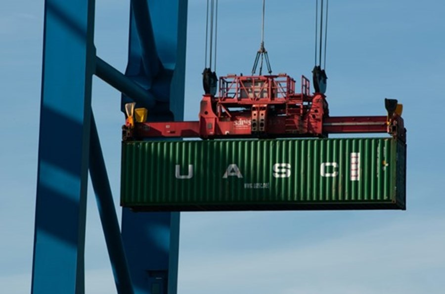 En stor grön container som lyfts upp av en lyftkran